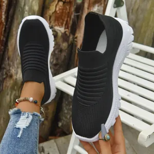 Close-up of black breathable knit sneakers showing slip-on design and textured sole
