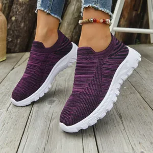 Detailed view of breathable purple fly-knit slip-on casual sneakers on wooden deck