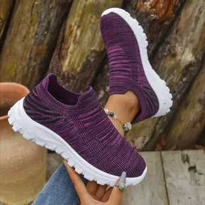 Detailed macro view of purple breathable fly-knit slip-on sneakers with white sole