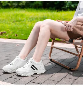 Vue latérale détaillée de baskets blanches à plateforme avec rayures noires en extérieur