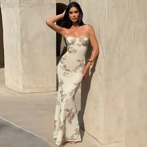 Close-up of an elegant cream bodycon maxi dress featuring intricate gold floral embroidery