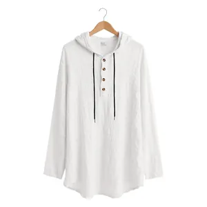 Detailed view of white linen hooded Henley shirt featuring black drawstrings and buttons.