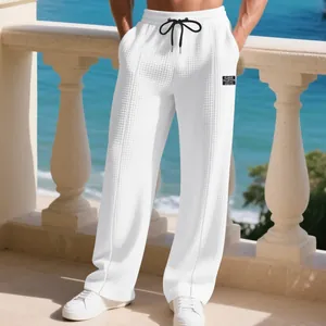 Detail of men's white waffle texture loose breathable sports pants on a balcony
