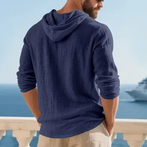 Detailed back view of a navy blue hooded linen shirt for men in a casual beach setting