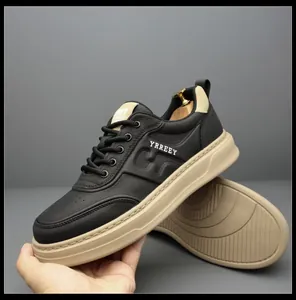 Close-up of black leather men's sneakers with beige thick soles and textured finish.