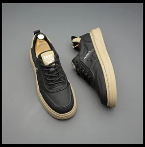 Close-up of stylish men's black leather board shoes featuring thick contrast tan soles.