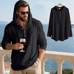 Detailed view of a black linen hooded Henley shirt for men on a scenic balcony.