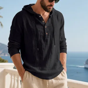 Detail view of men's black linen hooded Henley shirt in a scenic coastal setting