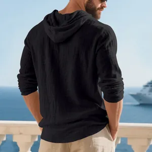 Back view of breathable black linen hooded long-sleeve T-shirt for men on a balcony