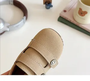 Macro view of a beige suede toddler walking shoe showing stitching and buckle detail