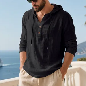Detailed view of a black linen hooded Henley shirt for men styled on a scenic beach balcony