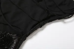 Detail of black backless dress showing 3D rose applique and criss-cross lacing.