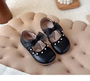 Detailed view of black girl's princess shoes with mesh bow and pearl trim accents