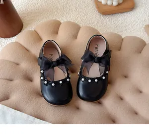 Detailed view of black girls' princess shoes with large mesh bows and pearl beads