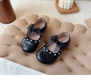 Detailed view of black children's Mary Jane shoes featuring mesh bow and pearl accents