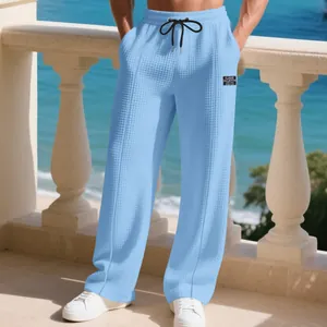 Detail of sky blue men's waffle texture pants with drawstring waist and label
