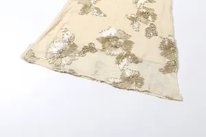 Detailed view of elegant mesh summer dress featuring metallic gold floral embroidery