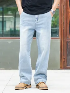 Close-up shot of men's loose straight-leg denim jeans in a stylish light blue wash finish.