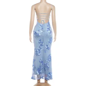 Close-up back view of blue maxi dress with lace-up straps and floral appliqués.