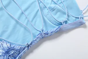 Intricate lace-up back detail of a stylish sky blue summer dress with floral accents