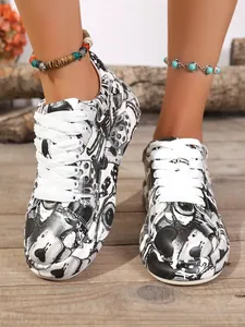 Front view of women's thick-soled sneakers with stylish black and white graffiti print