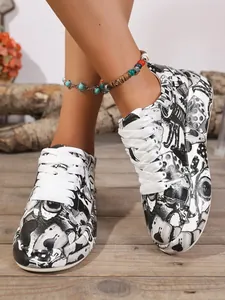 Detail of women's thick-sole sneakers with bold black and white graffiti print and laces.