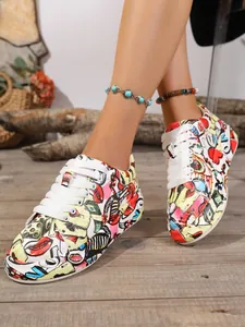 Close-up of vibrant cartoon graffiti print sneakers with white laces on wooden floor.
