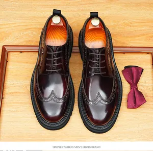 Top view of men's burgundy shiny leather brogue shoes with decorative carving