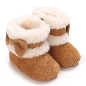Détail de bottes d'hiver marron pour bébé avec doublure en fausse fourrure blanche et nœud