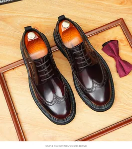 Detail of burgundy leather Derby shoes with wingtip brogue and thick black soles