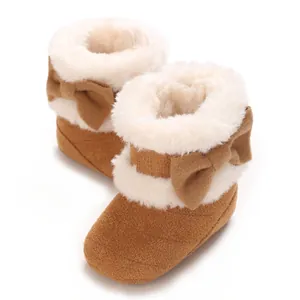 Gros plan de bottes d'hiver marron pour bébé avec doublure en fausse fourrure et nœud