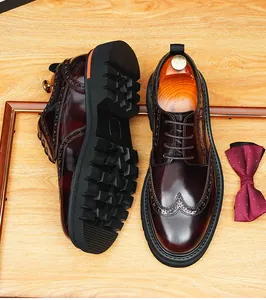 Detail view of men's burgundy leather brogue shoes with thick rubber soles and wingtip.