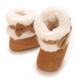Gros plan de bottes d'hiver marron pour bébé avec fausse fourrure blanche et un nœud