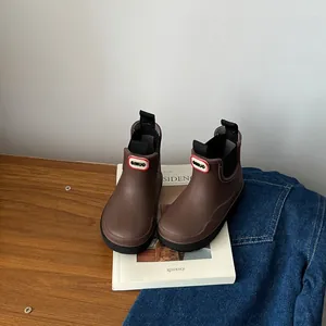Close-up of children's brown waterproof Chelsea rain boots with elastic side panels