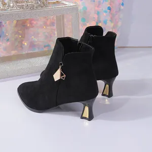Elegant black suede kitten heel ankle boots featuring a gold decorative charm detail