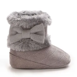Détail d'un chausson d'hiver gris pour bébé avec bordure en fausse fourrure et nœud
