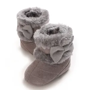 Vue détaillée des bottes d'hiver chaudes pour bébé avec fausse fourrure et décoration de nœud