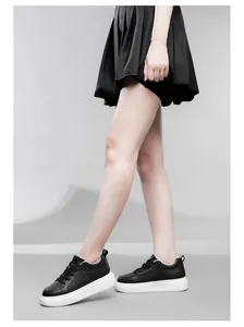 Vista laterale di eleganti sneakers nere con zeppa e suola bianca alta 6 cm da donna.