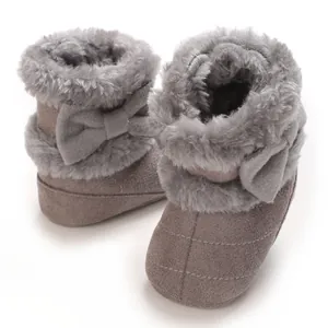 Vue détaillée des bottes de neige pour bébé grises avec doublure en fourrure et nœud.