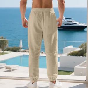 Λεπτομερής προβολή μπεζ λινό παντελόνι jogger για άνδρες με ελαστική μέση και μανσέτες.
