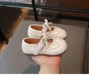 Vista dettagliata delle scarpe da principessa bianche per bambina con fiocco dolce e bordi ondulati