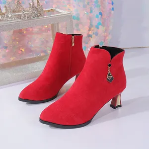 Close-up view of red pointed-toe suede ankle boots featuring elegant stiletto mid-heels