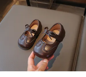 Primo piano di scarpe marroni stile Mary Jane da bambina con fiocco dolce e velcro
