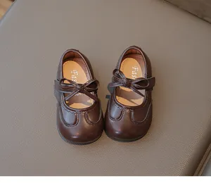 Dettaglio di scarpe Mary Jane marroni per bambina con un dolce fiocco decorativo.