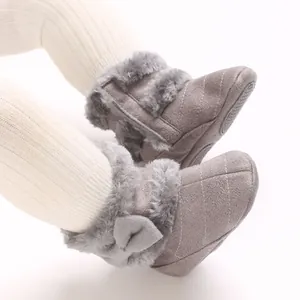 Vue détaillée de bottes d'hiver chaudes pour bébé avec nœud mignon et bordure en fausse fourrure