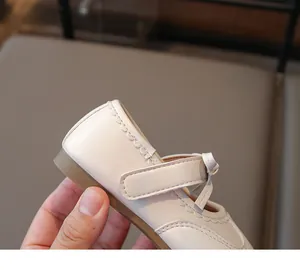 Dettaglio ravvicinato della scarpa Mary Jane in pelle beige per bambina con fiocco.