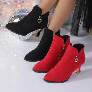 Close-up of elegant pointed-toe ankle boots with a sparkling heart-shaped ornament.