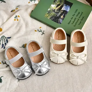 Elegante zilveren en crèmekleurige ballerina's voor meisjes met strik en klittenband.