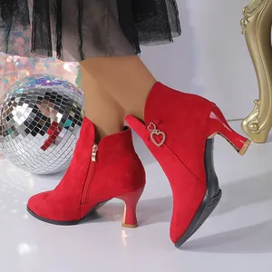 Detailed view of red suede ankle boot with heart-shaped rhinestone buckle and side zipper