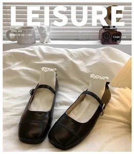 Close-up view of elegant black Mary Jane shoes for girls on soft white bedding